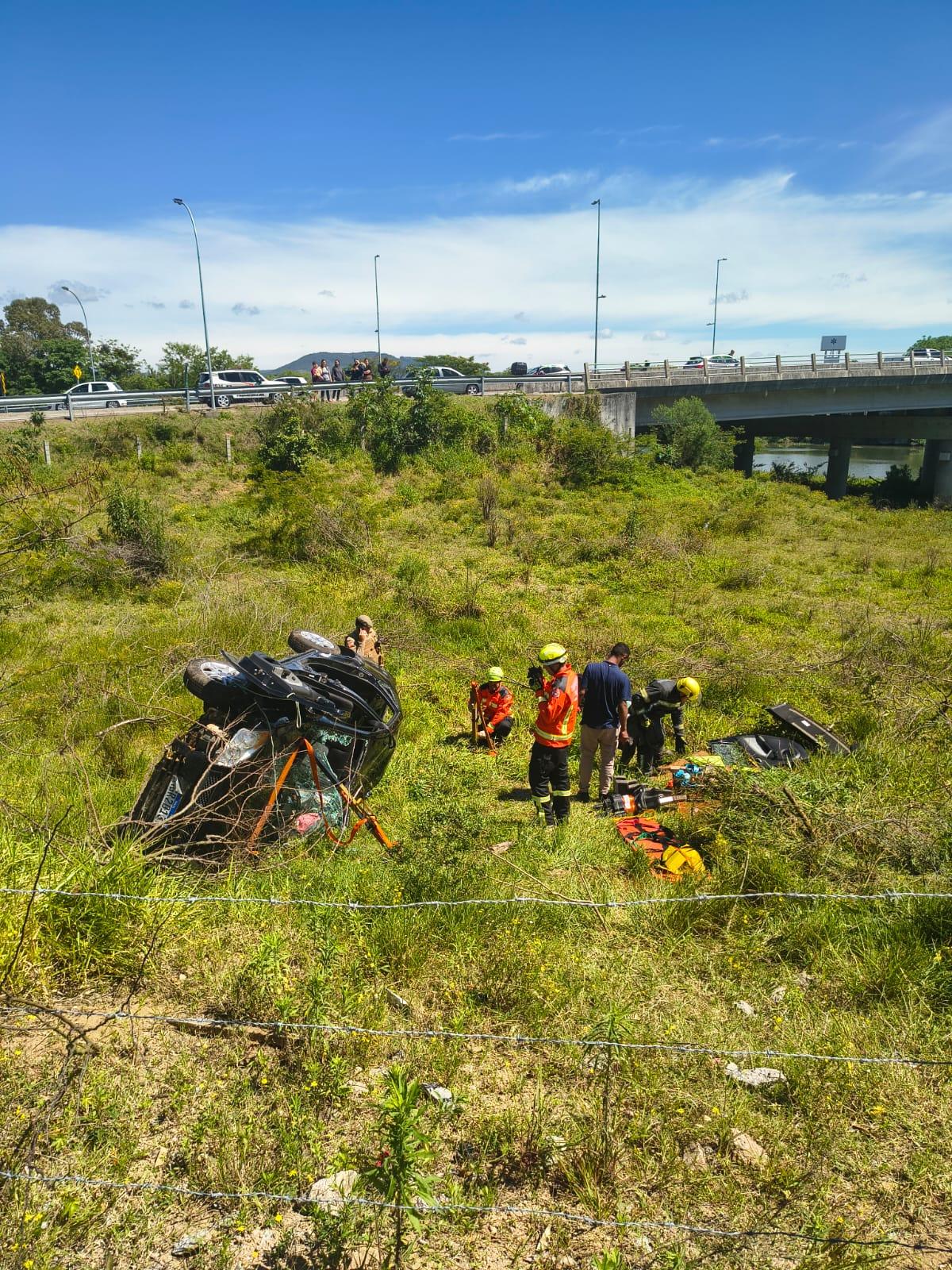 Carro cai em barranco na Cabeceira da Ponte da Amizade em Tubarão e bombeiros resgatam quatro vítimas
